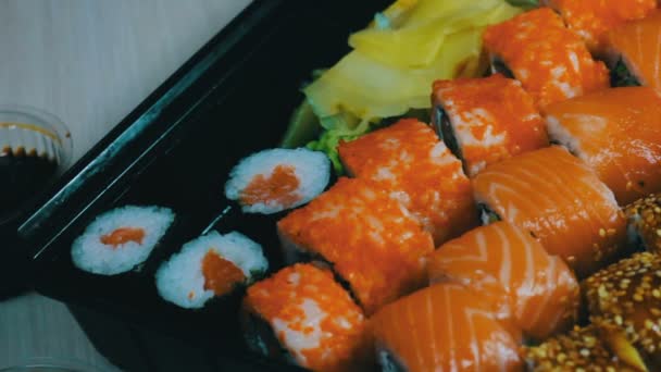 Lax maki rulle. Japansk sushi rätter med färska rå fisk. Japansk maträtt bestående av ris, lax eller tonfisk, räkor och fisk ägg indränkt i soja — Stockvideo