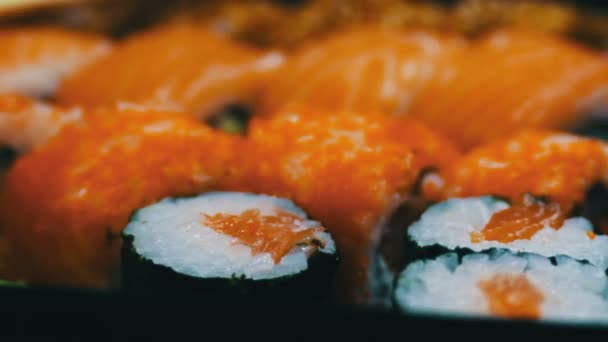 Ролл из лосося маки. Японская кухня суши со свежей сырой рыбой. Японское блюдо состоит из риса, лосося или тунца, креветок и рыбных яиц, пропитанных соей — стоковое видео