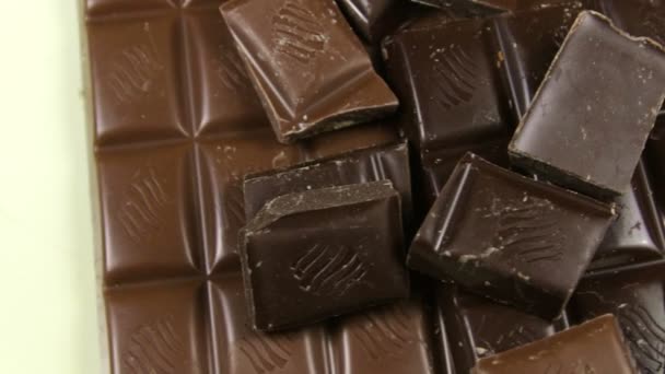 Melk en donkere chocolade tegels op een houten background.chocolate balken close-up — Stockvideo