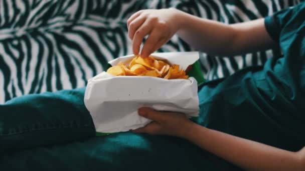 Chico comiendo paquete de papas fritas comida poco saludable — Vídeos de Stock