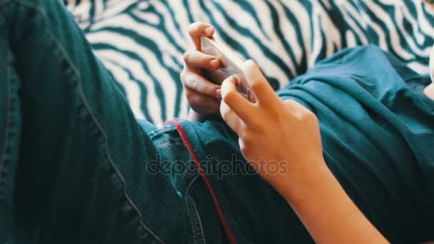 Menino jogando no smartphone no sofá em casa — Vídeo de Stock
