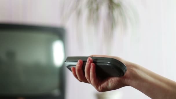 Nära upp skott av en manlig hand hålla Tv-fjärrkontrollen och byta TV-kanal — Stockvideo