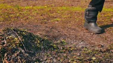 kadın geçen yıl kuru yaprakları bahçeden tırmıkla temizler.