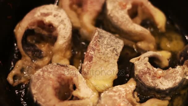 Stukken van zoetwater vis frituren in een gietijzeren koekepan. — Stockvideo