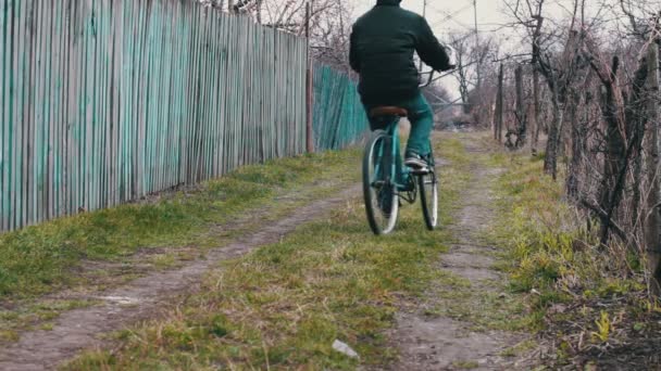 십 대는 마을을 통해 서 오래 된 빈티지 블루 자전거에 타기 — 비디오