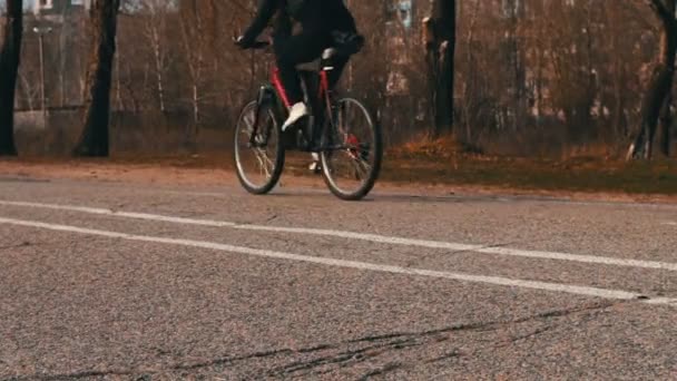 Cycliste sur un vélo rouge.pieds à pied sur la chaussée . — Video