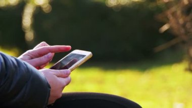 Kadın el smartphone kullanmak ve yüz kitap sosyal ağ sitesi, tipik haber göz atın