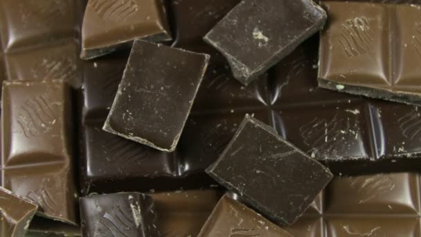 Milk and dark chocolate tiles on a wooden background.chocolate bars close up — Stock Video