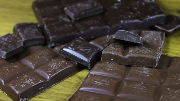 Leite e azulejos de chocolate escuro em um fundo de madeira. barras de chocolate fechar — Vídeo de Stock