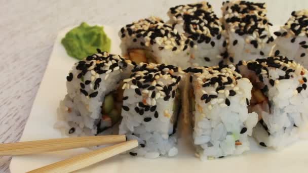 Čerstvé sushi rohlíky s sezamový losos zázvoru na bílém pozadí — Stock video
