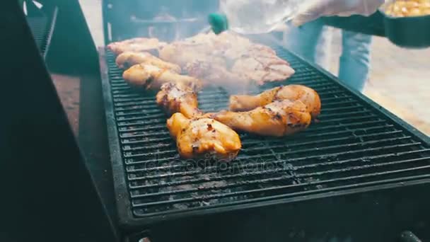 Куряче м'ясо, яке обертається на грилі барбекю. М'ясо смажать на грилі Мангал Барбекю. Куряче м'ясо на грилі під час пікніка — стокове відео