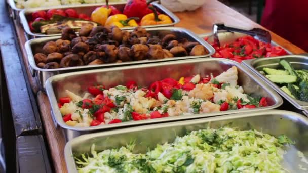 Counter with various salads and meat.Food is sold on the counter in cafe. People go through the cafe and choose their meals — Stock Video