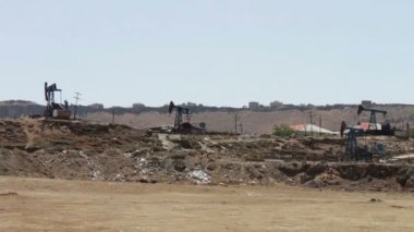 Bakı ş., Azerbaijan.Silhouette arka plan mavi gökyüzü ve bulutlar üzerinde çalışma yağ pompasının çalışma petrol alanında petrol pumpjacks. Petrol sahaları