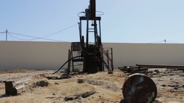 Pompes à huile dans un champ pétrolifère en marche à Bakou, Azerbaïdjan. Silhouette de pompe à huile en marche et un vieux baril de fer rouillé près d'un fond de ciel bleu et de nuages — Video