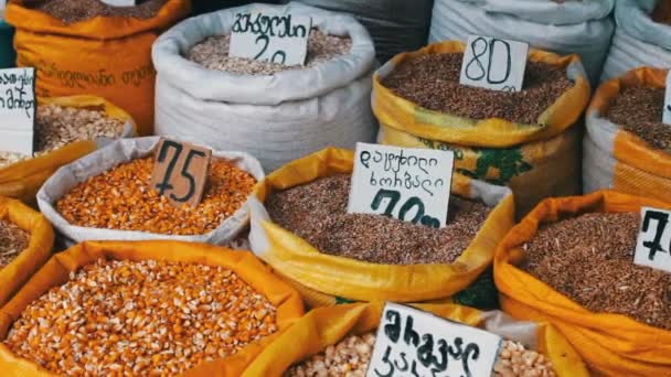 Muchas bolsas con diferentes cereales en las que cuelgan las etiquetas de precios están en el mercado — Vídeo de stock