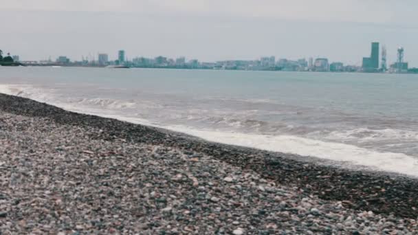 Las olas del mar golpean en la costa pedregosa en el terraplén del complejo urbano georgiano de Batumi — Vídeos de Stock