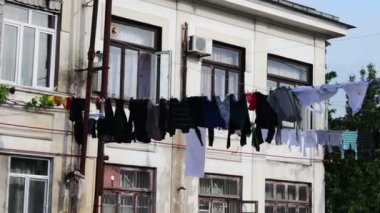 Yıkanmış Çamaşırhane çok sayıda bir ip üzerinde asılı ve evin yakınında sokakta kurur