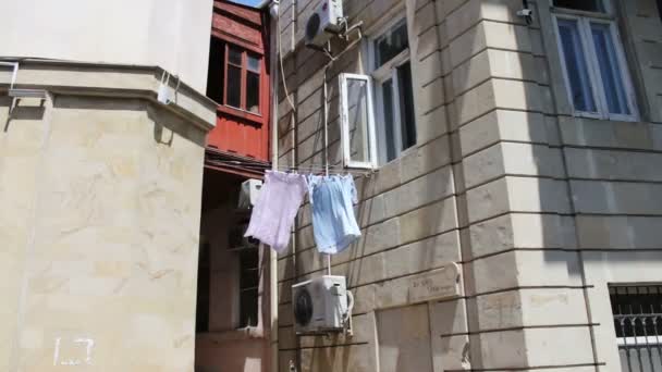 Les choses pendent aux cordes. Beaucoup de choses sèchent sur le balcon et se développent dans le vent — Video