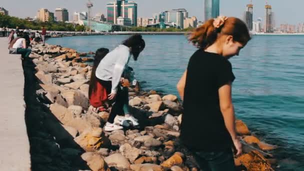 9 мая 2017 года - АЗЕРБАЙДЖАН, БАКУ: Люди сидят и ходят по знаменитой набережной Каспийского моря в Баку — стоковое видео