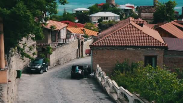 Maj 2017, Signaghi, Georgien: Man och kvinna läsa in stora väskor i bilar huven. Den vackra georgianska staden av Sighnaghi, på en höjd av 800 meter över havet. Gatorna i mysig småstad. — Stockvideo