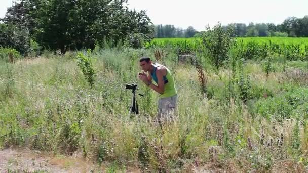 Оператор знімає природний пейзаж на відеокамеру в селі — стокове відео