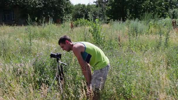 El camarógrafo dispara el paisaje natural en la cámara de vídeo en el pueblo — Vídeos de Stock