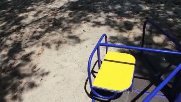 Разноцветная детская карусель в детском парке кружится и ждет детей — стоковое видео