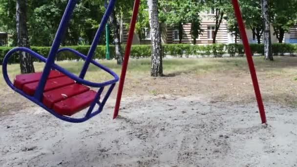 Röd childrens swing gungor från sida till sida i sommar — Stockvideo