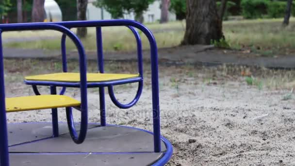 Різнокольоровий дитячий карусель в дитячому парку обертається і чекає дітей — стокове відео