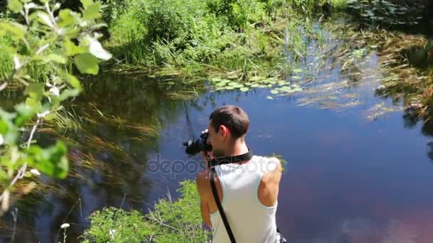 Оператор знімає природний річковий пейзаж на відеокамеру — стокове відео