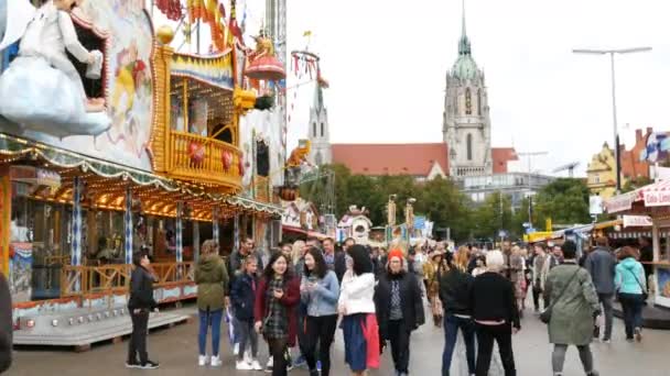 17 de setembro de 2017 - Munique, Alemanha: O maior festival de cerveja do mundo Oktoberfest. Pessoas em trajes bávaros nacionais Lederhose e Dirdln caminham em torno de passeios de diversão em Theresienwiese — Vídeo de Stock