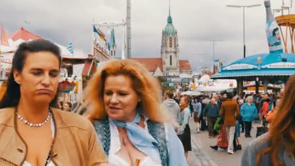 17 września 2017 - Monachium: tłum ludzi ubranych w stroje ludowe bawarskie spacer wzdłuż Oktoberfest przeszłości atrakcje rozrywkowe i namioty z jedzeniem i słodycze — Wideo stockowe