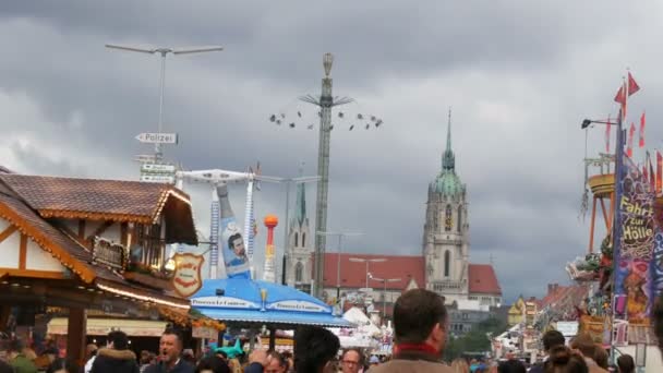 17 settembre 2017 - Monaco di Baviera, Germania: una folla di persone vestite con costumi bavaresi nazionali cammina lungo l'Oktoberfest passando per attrazioni e tende di intrattenimento con cibo e dolci — Video Stock