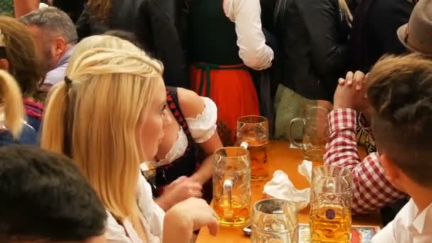 2017 年 9 月 17 日 - ミュンヘン, ドイツ: A 多数ガラス ビール ジョッキのビールでいっぱい。オクトーバーフェスト、バイエルン州の有名な祭りでくつろぐ人々 — ストック動画