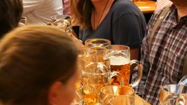 17 settembre 2017 - Monaco di Baviera, Germania: Un gran numero di boccali di birra di vetro pieni di birra. La gente riposa sull'Oktoberfest, il festival di fama mondiale in Baviera — Video Stock