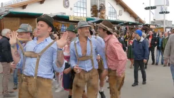 September 17, 2017 - Oktoberfest, Munich, Germany: Merry company of young people in national Bavarian suits Lederhose and colorful checkered shirts to have fun at Theresienwiese — Stock Video