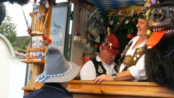 17 settembre 2017 - Oktoberfest, Monaco di Baviera, Germania: Uomini impressionanti in abiti bavaresi nazionali e cappelli a penna comunicano con la gente e ridono — Video Stock