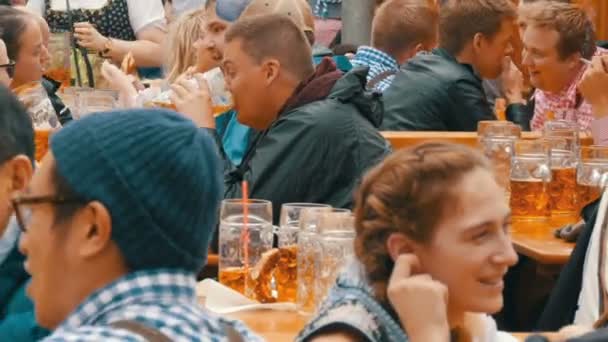 17 de septiembre de 2017 - Oktoberfest, Múnich, Alemania: La gente descansa, ríe divirtiéndose y se sienta a beber cerveza de enormes tazas de vidrio en Theresienwiese en Baviera en el Festival Mundial de la Cerveza — Vídeo de stock