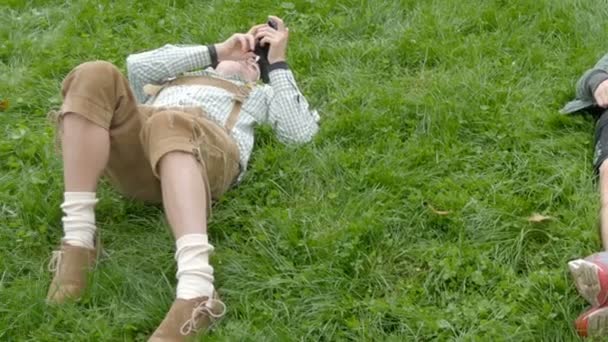 17 de septiembre de 2017 - Oktoberfest, Múnich, Alemania: Los jóvenes se emborrachan y descansan en un prado verde. Celebración en el mundialmente famoso festival de la cerveza — Vídeos de Stock