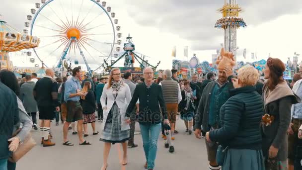 17 сентября 2017 - Октоберфест, Мюнхен, Германия: толпа людей ходит и веселится по всему миру на пивном фестивале возле аттракционов и палаток с едой — стоковое видео