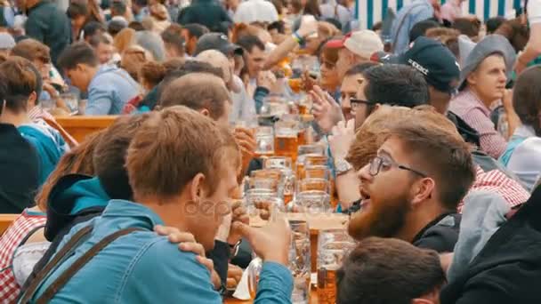 September 17, 2017 - Oktoberfest, München, Tyskland: Människor sit dricka öl ur stora glas muggar på Theresienwiese i Bayern på World Beer Festival — Stockvideo