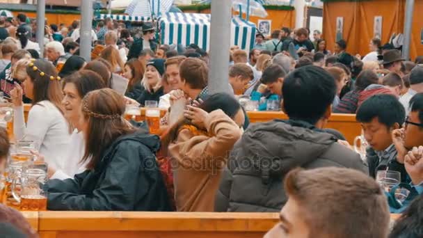 17 de setembro de 2017 Oktoberfest, Munique, Alemanha: As pessoas sentam-se bebendo cerveja de enormes canecas de vidro em Theresienwiese, na Baviera, no Festival Mundial da Cerveja — Vídeo de Stock