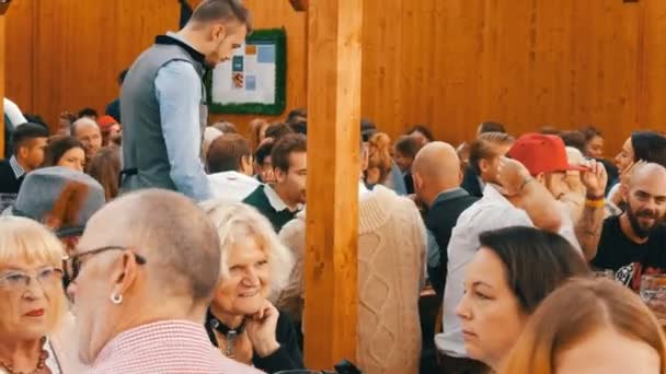 17. September 2017 - oktoberfest, München, Deutschland: Menschen ruhen, lachen, haben Spaß und sitzen und trinken Bier aus riesigen Glasbechern auf der Theresienwiese in Bayern beim Weltbierfest — Stockvideo