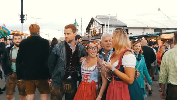 17 de septiembre de 2017 - Oktoberfest, Múnich, Alemania: multitud de personas caminando y divirtiéndose alrededor del festival mundial de la cerveza cerca de atracciones y tiendas de campaña con comida — Vídeos de Stock