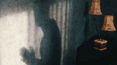 Vintage sarı lamba, yanındaki Gotik bir karanlık odada bir uğursuz gölge öfkeyle ellerini losyonları. Hayalet ya da bir cadı Cadılar Bayramı için.