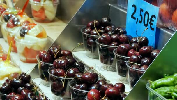 22. září 2017 - Barcelona, Španělsko, Mercator de la Boqueria potravinový trh: velký pult s tropické ovoce, mango, mučenka, kiwi, banány v plastových obalech — Stock video
