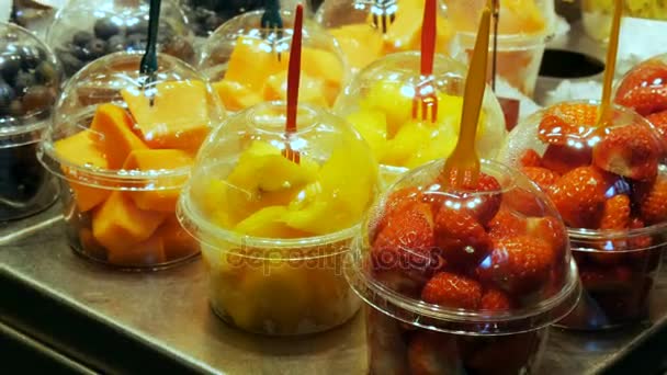 Szeptember 22-én, 2017 - Barcelona, Spanyolország, Mercator de la Boqueria élelmiszerpiac: trópusi gyümölcsök, mangó, passiógyümölcs, kivi, banán, műanyag csomagolás óriási pult — Stock videók
