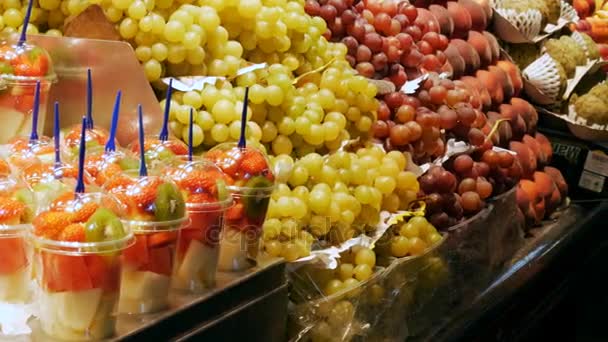 22 september, 2017 - Barcelona, Spanje, Mercator de la Boqueria Food Market: een enorme teller met tropische vruchten, mango, passievrucht, kiwi, bananen in plastic verpakkingen — Stockvideo