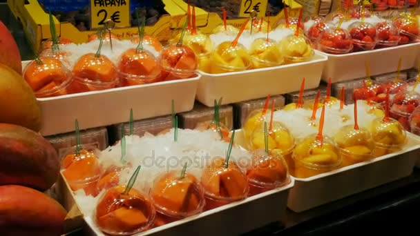 Szeptember 22-én, 2017 - Barcelona, Spanyolország, Mercator de la Boqueria élelmiszerpiac: trópusi gyümölcsök, mangó, passiógyümölcs, kivi, banán, műanyag csomagolás óriási pult — Stock videók