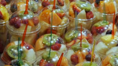 Meyve pazarının raflarda plastik bardaklarda farklı meyve karışımı